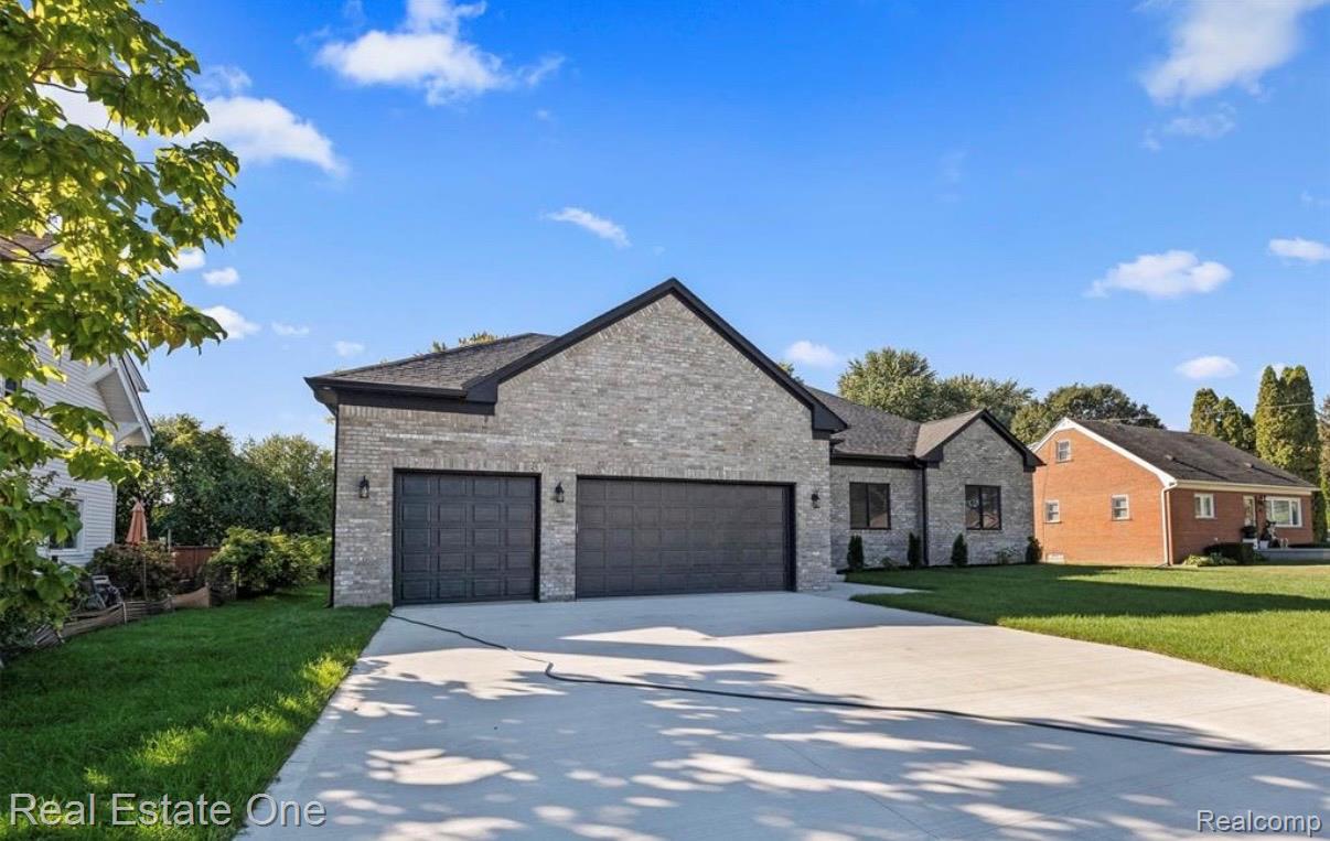 5636 Paris Street Sterling Heights, MI 48310 - Photo 2 of 37 View of front of property featuring a garage, a front yard, driveway, and brick siding