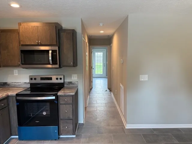 a kitchen with stainless steel appliances granite countertop a stove a sink and a refrigerator