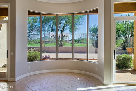 a view of an empty room and a kitchen