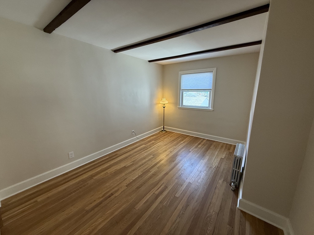 19 Chauncey Street, Unit 2 Watertown, MA 02472 - Photo 12 of 17 a view of an empty room with wooden floor and a window
