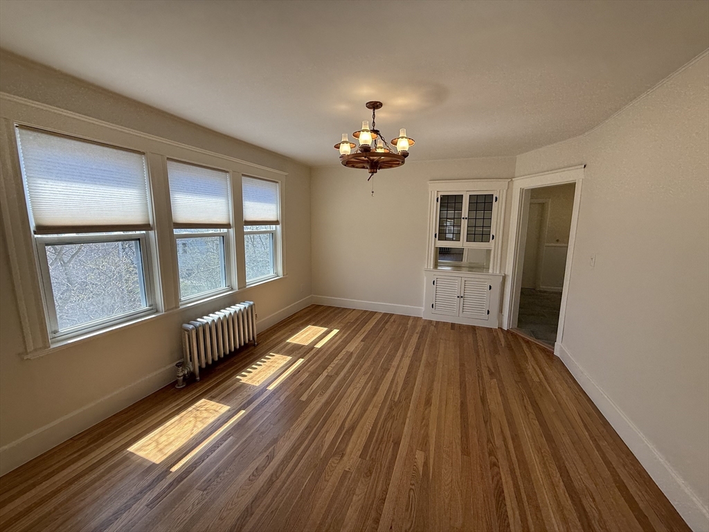 19 Chauncey Street, Unit 2 Watertown, MA 02472 - Photo 4 of 17 wooden floor in an empty room with a window