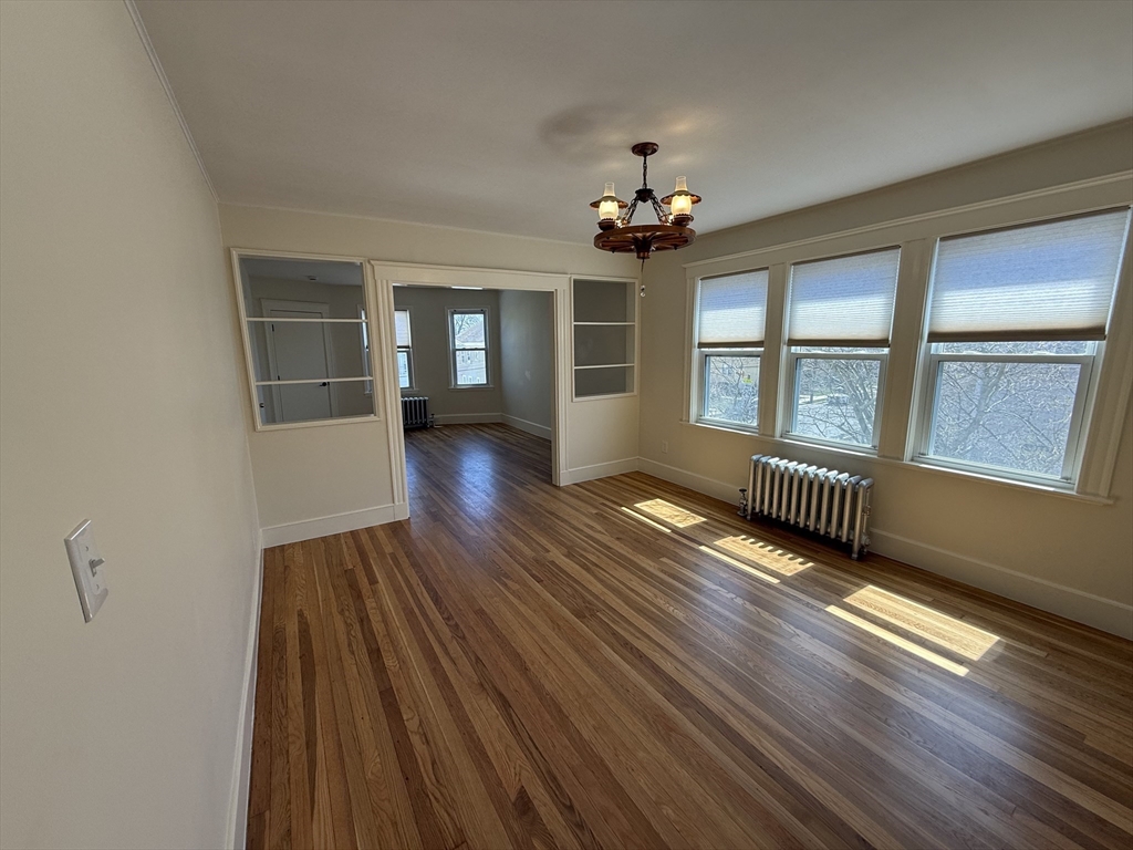 19 Chauncey Street, Unit 2 Watertown, MA 02472 - Photo 5 of 17 wooden floor in an empty room with a window