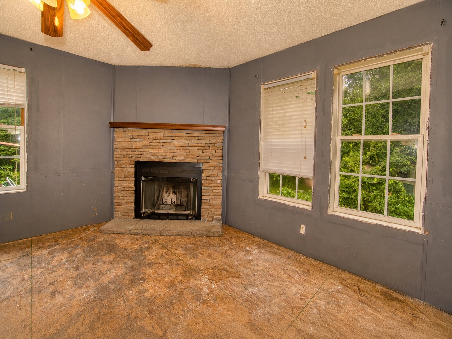 461924 East 1140 Road Sallisaw, OK 74955 - Photo 8 of 29 Central fireplace featuring a stone surround and wood mantel