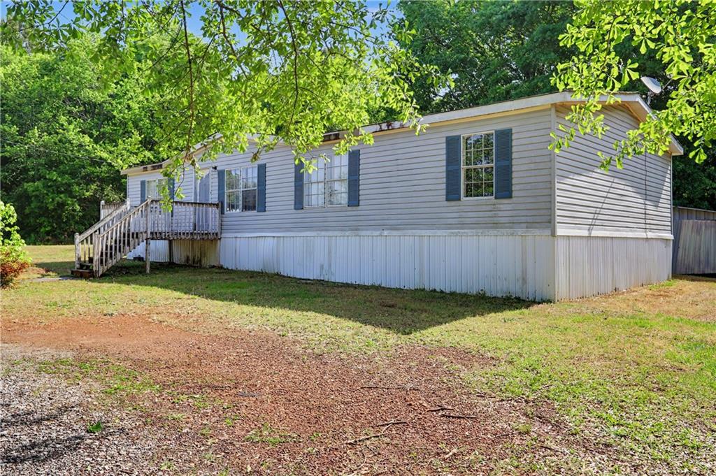 249 John Golden Road Temple, GA 30179 - Photo 4 of 45 a backyard of a house with wooden fence and large trees