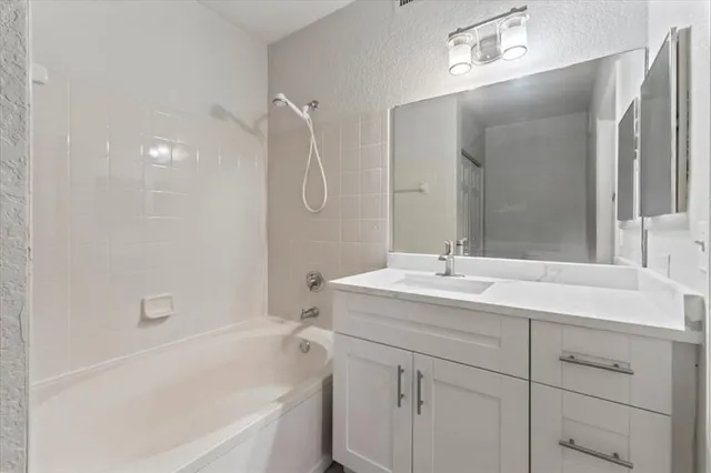 a bathroom with a tub sink and mirror
