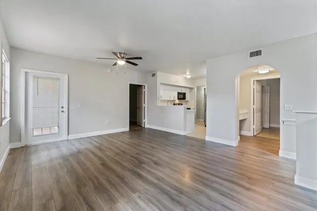 a view of a livingroom with wooden floor and a ceiling fan
