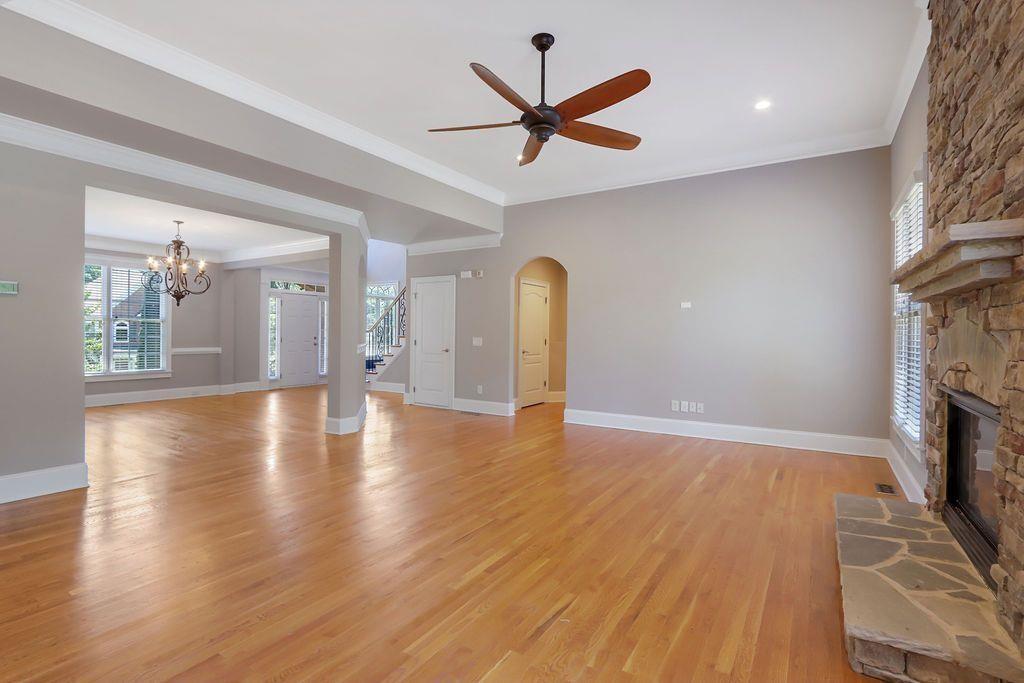 4174 Highglen Trace Northeast Dacula, GA 30019 - Photo 14 of 48 a view of a livingroom with a fireplace a ceiling fan and wooden floor