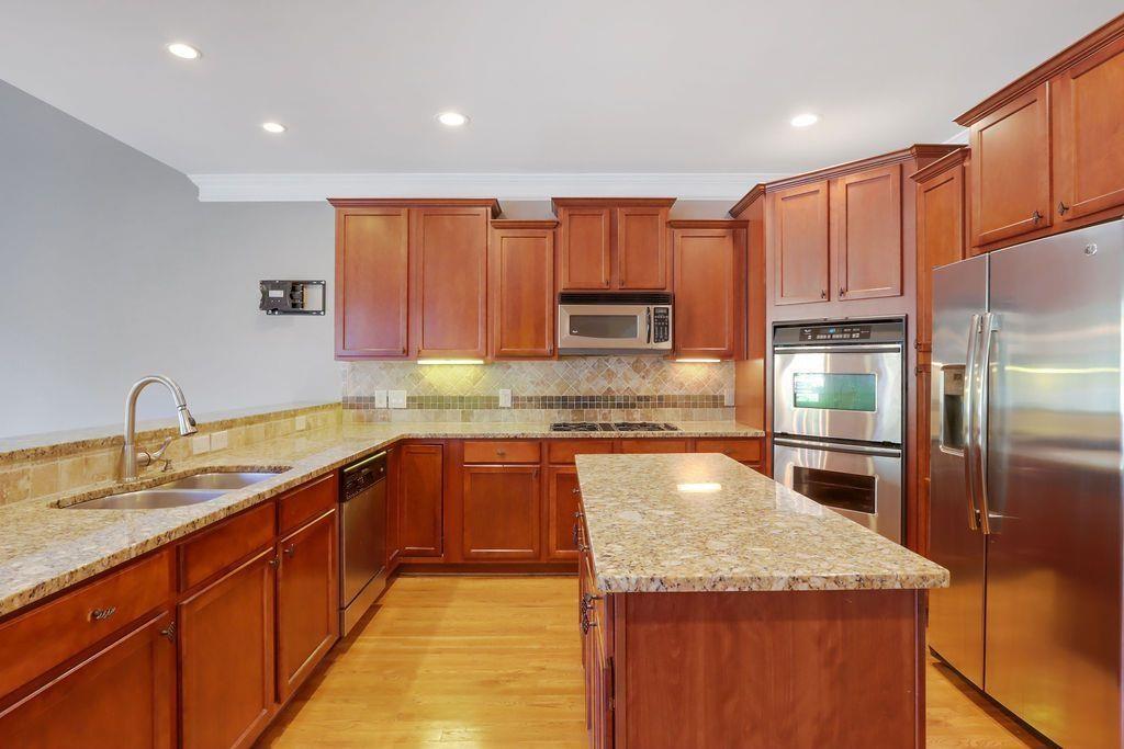4174 Highglen Trace Northeast Dacula, GA 30019 - Photo 20 of 48 a kitchen with stainless steel appliances granite countertop a sink refrigerator and cabinets