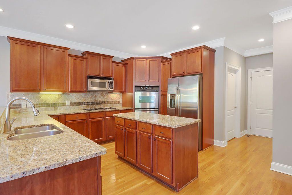 4174 Highglen Trace Northeast Dacula, GA 30019 - Photo 21 of 48 a kitchen with stainless steel appliances granite countertop wooden cabinets a sink and a stove