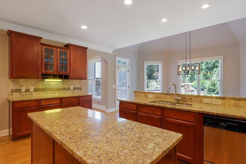 4174 Highglen Trace Northeast Dacula, GA 30019 - Photo 22 of 48 a kitchen with kitchen island granite countertop wooden cabinets and a refrigerator