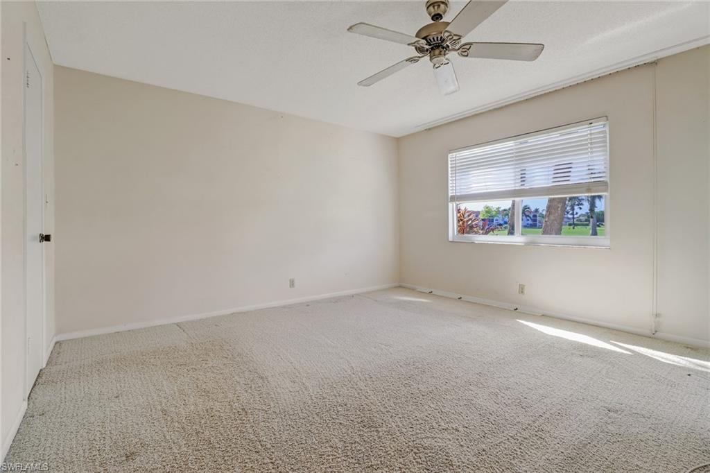 9 High Point Circle North, Unit 106 Naples, FL 34103 - Photo 20 of 35 Master bedroom with view of the golf course