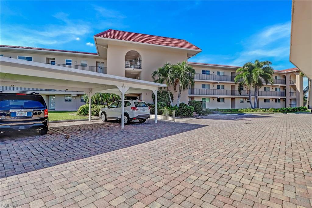 9 High Point Circle North, Unit 106 Naples, FL 34103 - Photo 2 of 35 Building with one covered parking space.