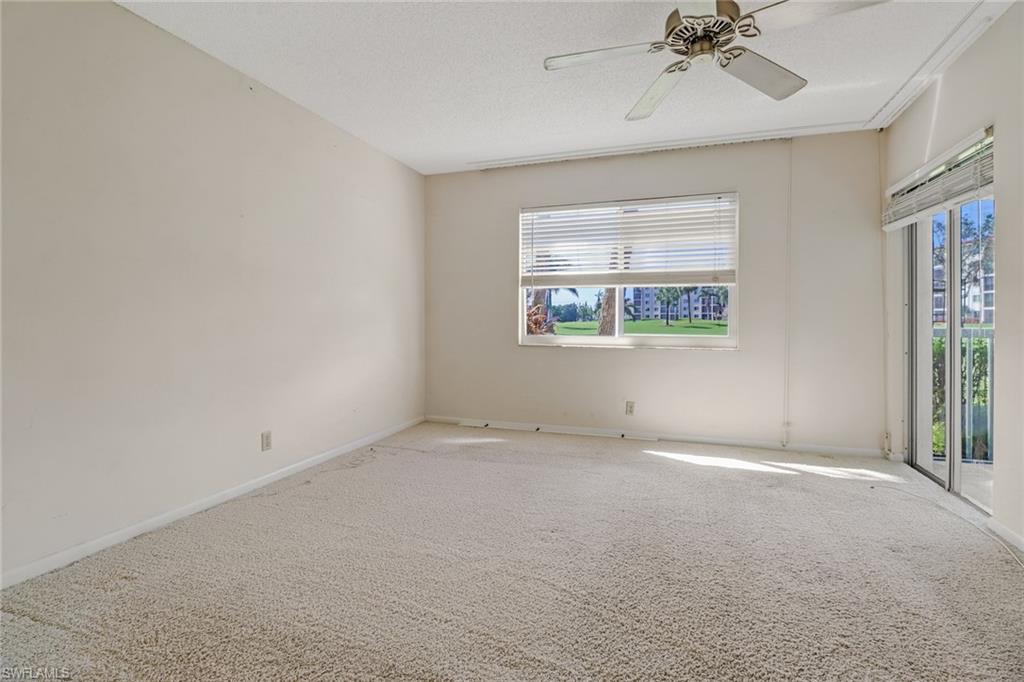 9 High Point Circle North, Unit 106 Naples, FL 34103 - Photo 21 of 35 Master bedroom with door to the lanai