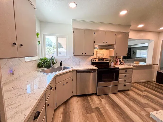 a kitchen with kitchen island a sink appliances and living room view