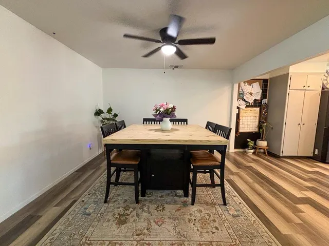 a dining room with furniture a chandelier and wooden floor