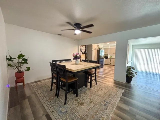 a dining room with wooden floor and a rug