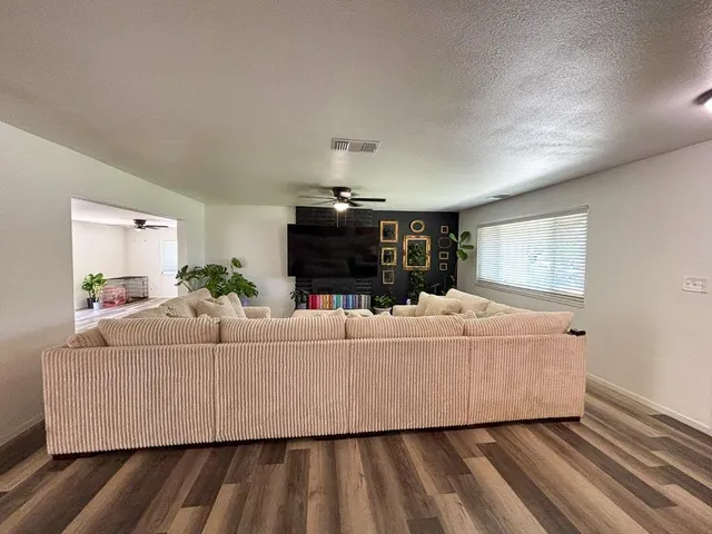 a living room with furniture and a ceiling fan