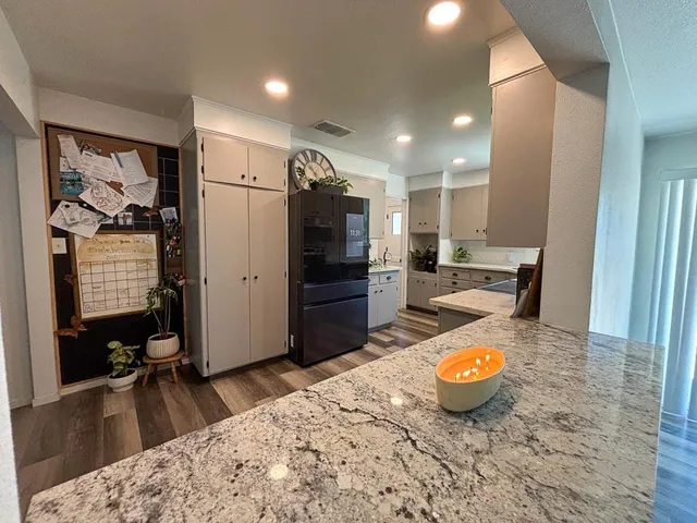 a kitchen with kitchen island a counter top space a sink stainless steel appliances and cabinets