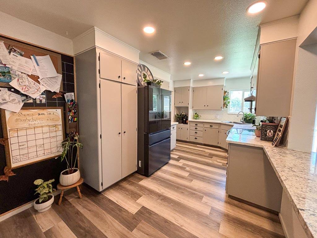 1237 De Cesari Avenue Madera, CA 93637 - Photo 9 of 33 a kitchen with kitchen island a counter top space a sink stainless steel appliances and cabinets