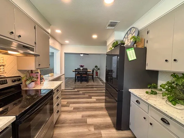 a kitchen with granite countertop white cabinets and white appliances