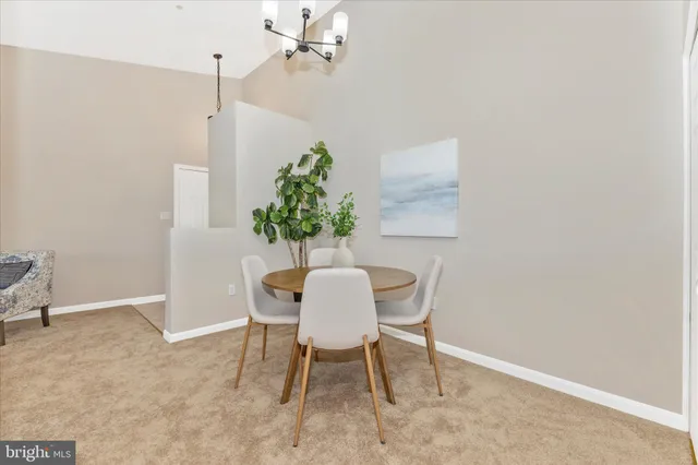 a dining room with furniture potted plants and wooden floor