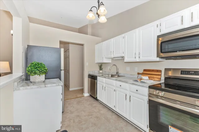 a kitchen with cabinets stainless steel appliances and a counter space