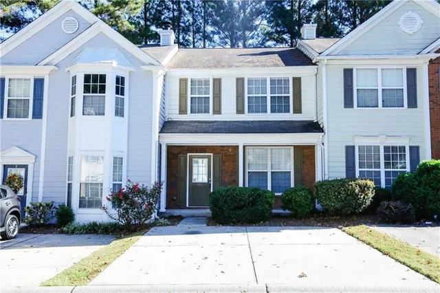 a front view of a house with yard and green space