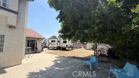 2478 KOA Drive Rialto, CA 92377 - Photo 11 of 18 a view of a patio with table and chairs under an umbrella with large trees