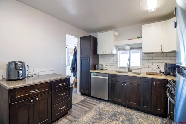 a bedroom with a bed and a lamp on dresser