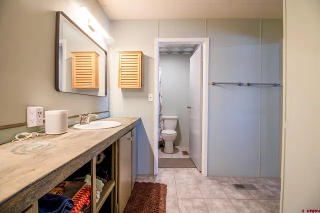 a bathroom with a granite countertop toilet and a sink