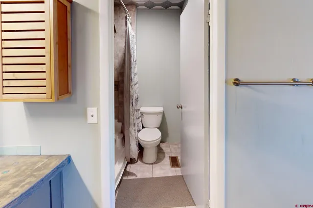 a bathroom with a sink a toilet and shower curtain