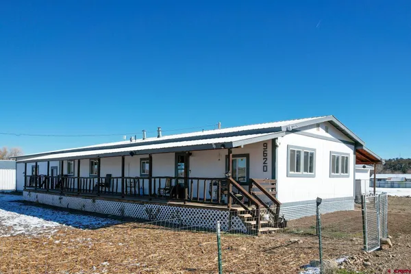 a view of a house with a yard and wooden fence