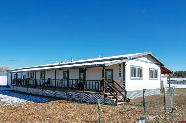 a view of a house with a yard and wooden fence