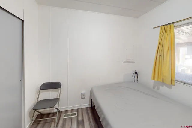 a view of empty room with window and wooden floor