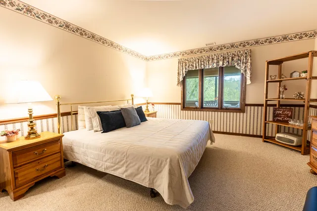 a bedroom with a bed and large windows