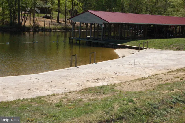 a view of swimming pool with lawn chairs and wooden fence