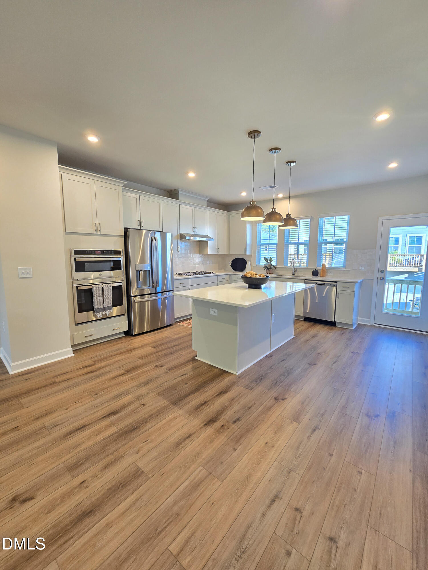 1112 Holding Village Way Wake Forest, NC 27587 - Photo 11 of 45 a kitchen with stainless steel appliances kitchen island wooden floors and cabinets