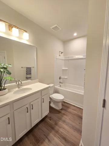 a bathroom with a toilet a sink a tub and mirror