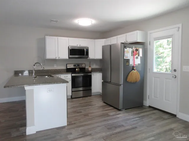 a kitchen with stainless steel appliances granite countertop a refrigerator sink and microwave