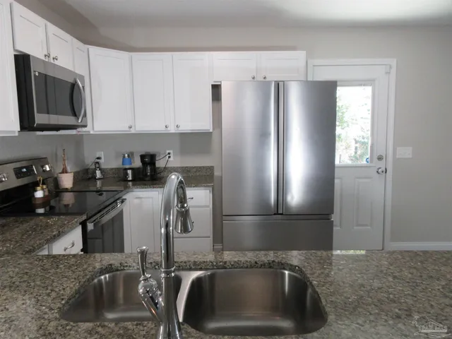 a kitchen with stainless steel appliances granite countertop a stove and a microwave