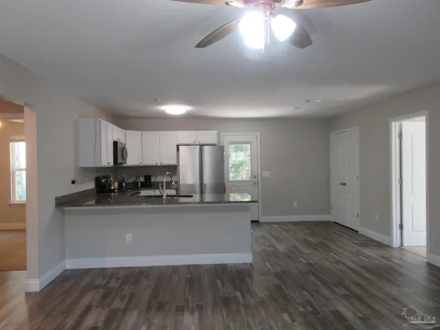 a view of a room with wooden floor and a ceiling fan