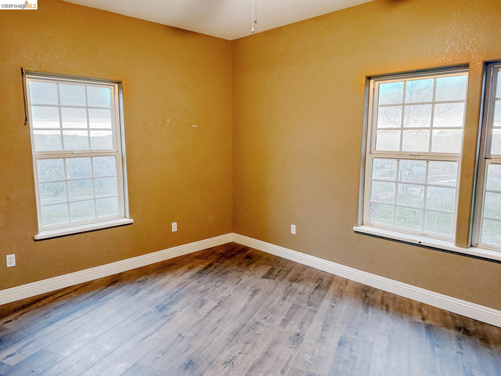 16446 Stamp Mill Loop Road East Jamestown, CA 95327 - Photo 24 of 32 an empty room with wooden floor and windows