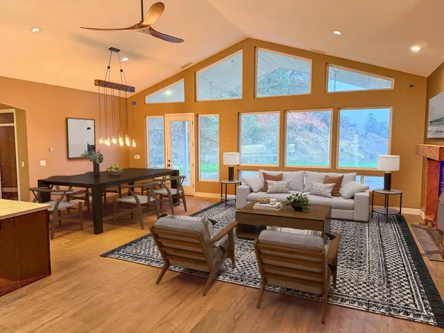 a living room with furniture a fireplace and large windows