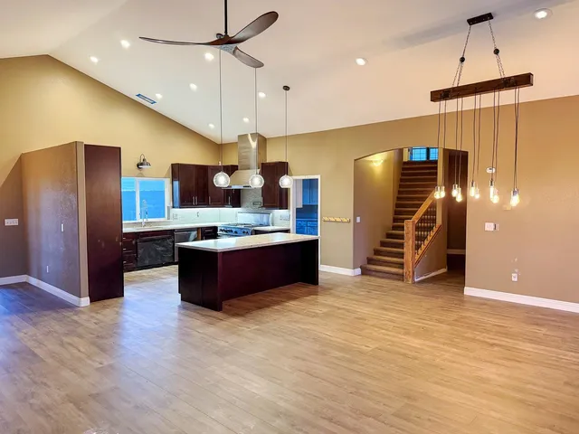 a large kitchen with stainless steel appliances a large counter top a refrigerator and a stove