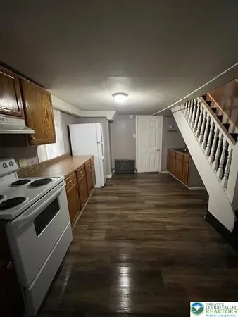 a kitchen with wooden floors and appliances