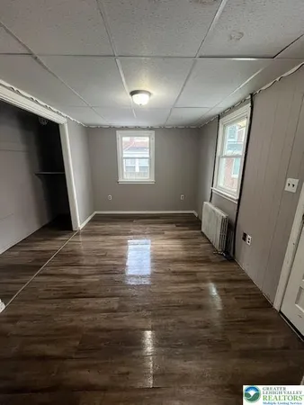 a view of empty room with wooden floor