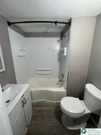 a white toilet sitting next to a bath tub