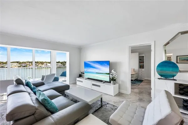 a living room with furniture a rug and kitchen view