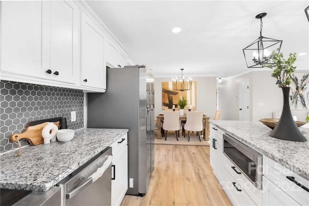 2606 Holbrook Road Fort Mill, SC 29715 - Photo 11 of 23 a kitchen with granite countertop white cabinets and chandelier