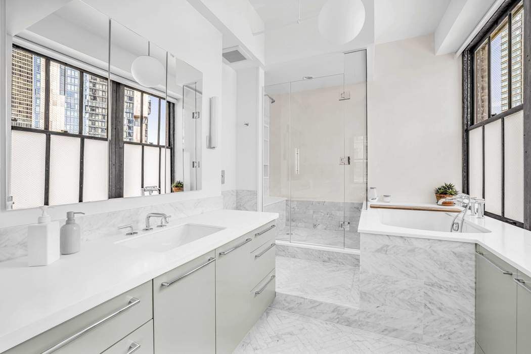 11 West 30th Street, Unit 14 Manhattan, NY 10001 - Photo 10 of 18 a spacious bathroom with a tub sink and mirror